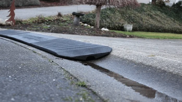 A Bridjit curb ramp with a water channel to allow storm runoff to flow underneath