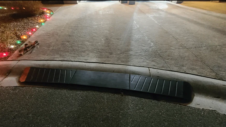 A Bridjit curb ramp with tapered ends for curved driveway entries