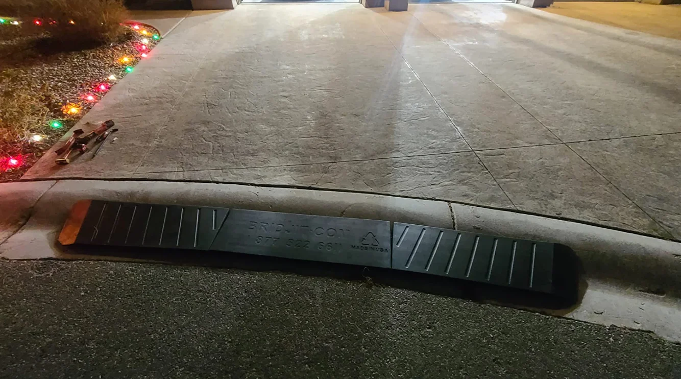 A curb ramp with superior traction features for vehicles on slippery conditions