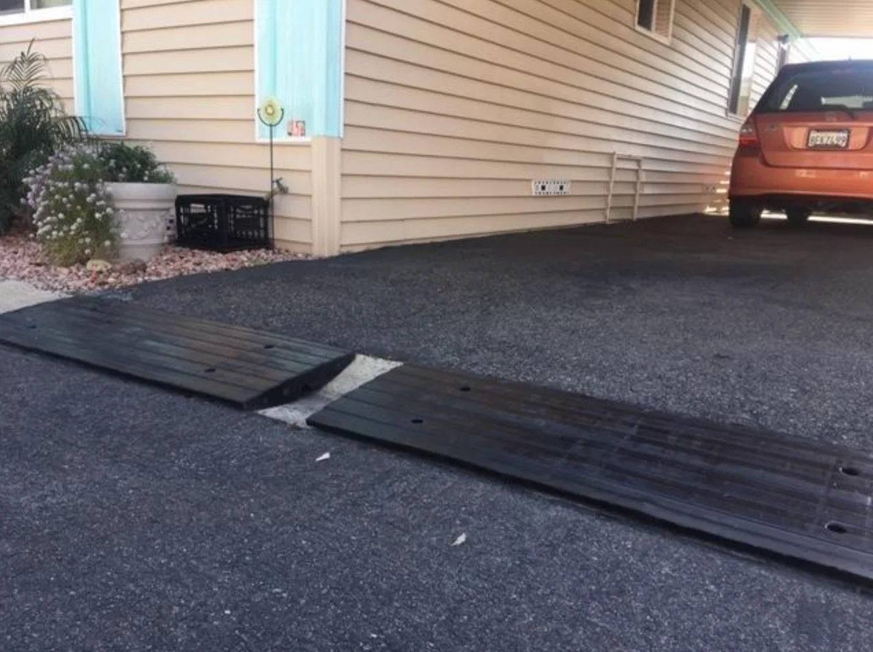 A rubber curb ramp installed in a driveway