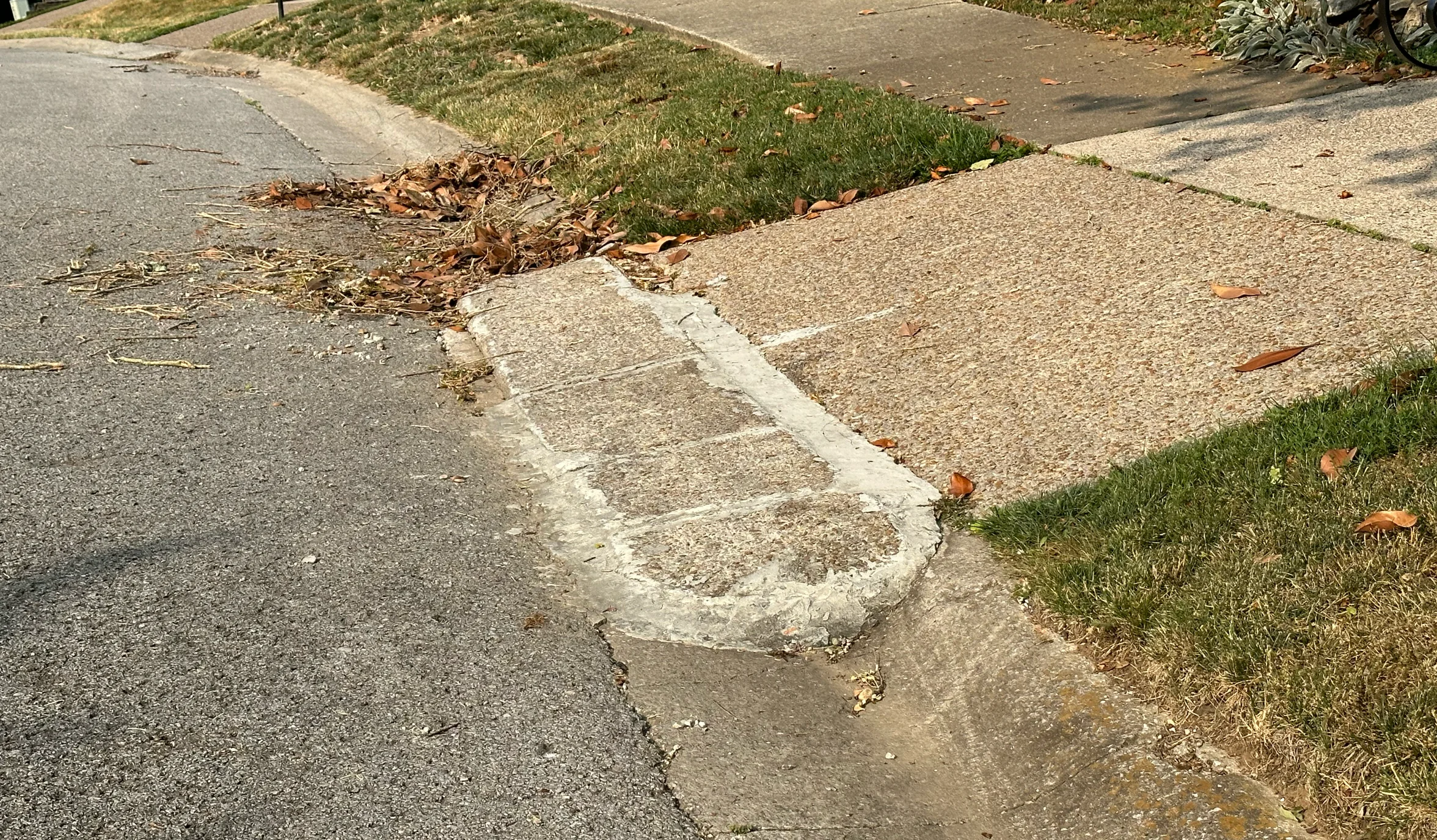 A driveway with a concrete curb ramp installed